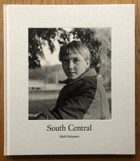 The photography book cover of South Central by Mark Steinmetz. Hardback with black and white photo of a boy staring into the camera.