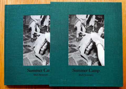 The photography book cover of Summer Camp by Mark Steinmetz. Hardback slipcased signed edition in dark green with centred image of someone doing the limbo.