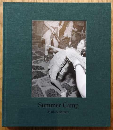 The photobook cover of Summer Camp from Mark Steinmetz. Hardback with dark green border around photo of a girl doing the limbo. Signed.