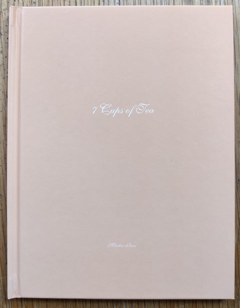 The photography book cover of 7 Cups of Tea by Martin Parr. Hardback in baby pink with white text. Signed.