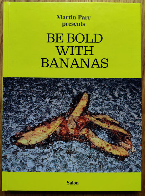 The photography book cover of Be Bold with Bananas by Martin Parr. Hardback in yellow with image of a smashed banana. Signed.