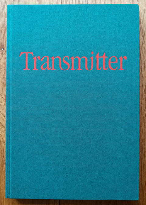 The photography book cover of Transmitter by Matthew Spiegelman. Hardback in blue with red title.