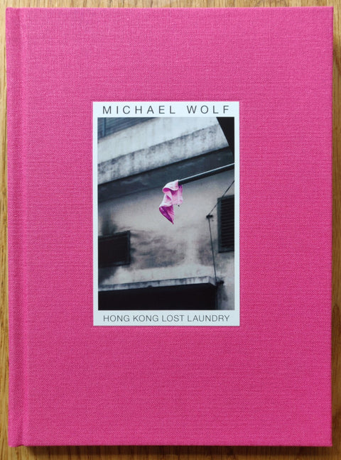 The photography book cover of Hong Kong Lost Laundry by Michael Wolf. Hardback in pink.