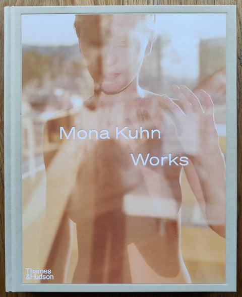 The photography book cover of Works by Mona Kuhn. Hardback with nude image on the cover. White text. Signed.