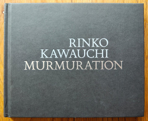 The photography book cover of Murmuration by Rinko Kawauchi. Hardback in dark grey. Signed.