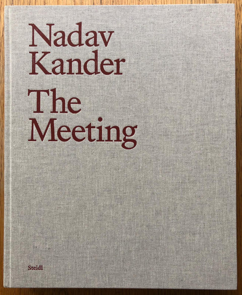 The photography book cover of The Meeting by Nadav Kander. Hardback in beige with dark red/brown title. Signed.