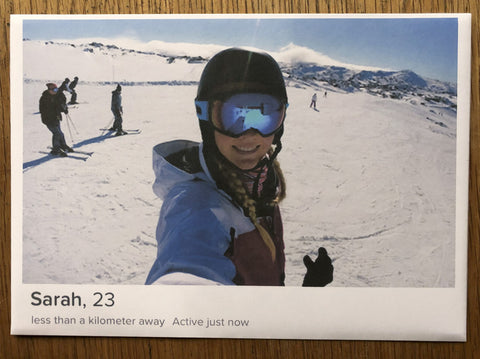 The photography book cover of Netflix and Chill by Now A Magpie. Print of a girl on a ski slope smiling at the camera. Signed.