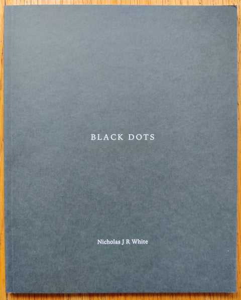 The photography book cover of Black Dots by Nicholas J R White. In softcover green.