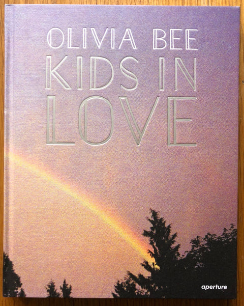 The photography book cover of Kids in Love by Olivia Bee. Hardback with image of rainbow on cover.