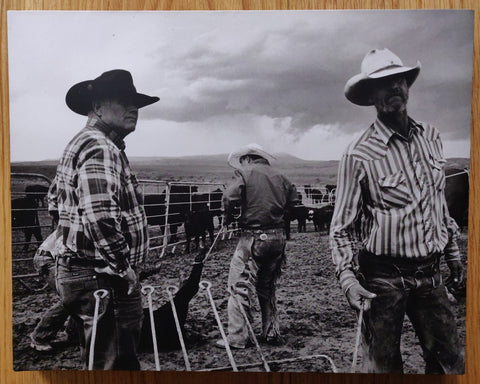 The photography book cover of Open Range by John Langmore. Hardback in B&W with three cowboys on the cover.