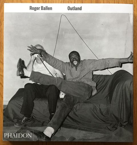 The photography book cover of Outland by Roger Ballen. Hardback black and white cover.