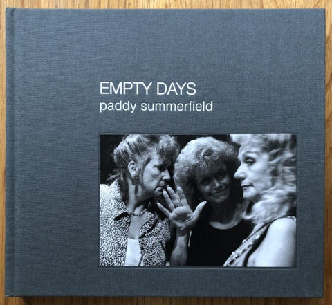 The photography book cover of Empty Days by Paddy Summerfield. Hardback in grey and photograph of 3 women on the cover.