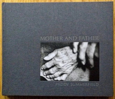The photography book cover of Mother and Father by Paddy Summerfield. Hardback in grey with photo of hands on the cover.
