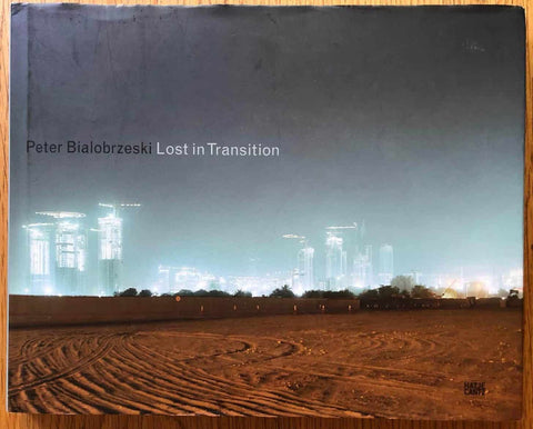 The photobook cover of Lost in Transition by Peter Bialobrzeski. Hardback with image of the city in the distance.