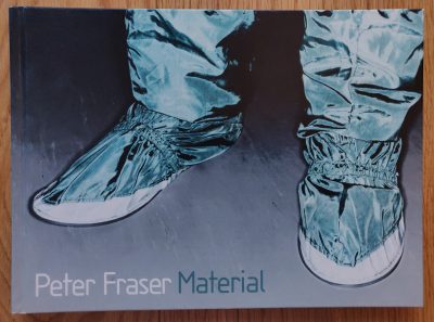 The photography book cover of Material by Peter Fraser. Hardback with image of feet in protective clothing.