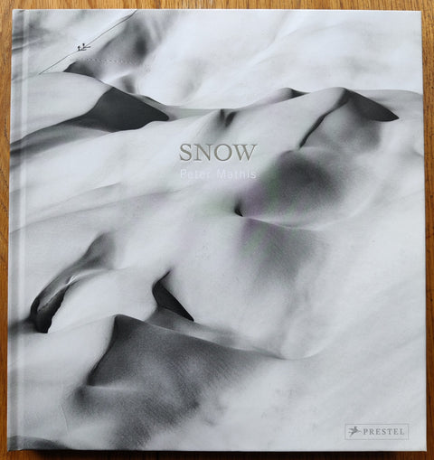 The photography book cover of Snow by Peter Mathis. Hardback in black and white.