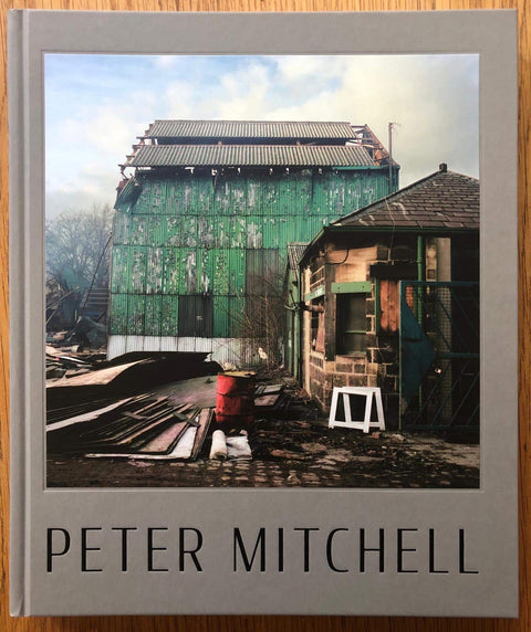 The photography book cover of Early Sunday Morning by Peter Mitchell. Hardback in grey with picture of building site. Signed.