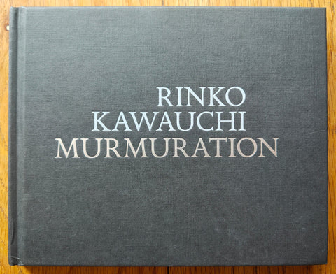The photography book cover of Murmuration by Rinko Kawauchi. Hardback in dark grey. Signed.