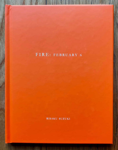 The photography book cover of Fire: February 6 by Risaku Suzuki. Hardback in orange. Signed.
