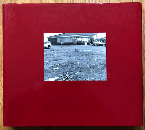 The photography book cover of What We Bought: The New World by Robert Adams. Hardback in red. Signed.