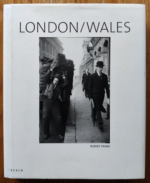 The photography book cover of the first edition of London / Wales by Robert Frank. In dust jacketed hardcover black.