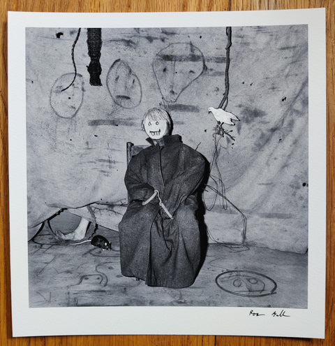 The photography book cover of Appearances, Disappearances, Reappearances by Roger Ballen. Hardback in black with print of a mixed photographic/drawing of someone sitting down on a chair. Signed.