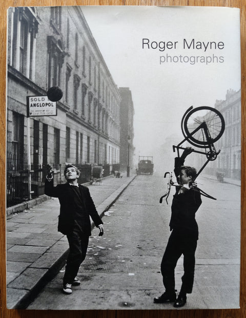 The photography book cover of  Roger Mayne: Photographs by Roger Mayne. In dust jacketed hardcover black and white with two boys playing.
