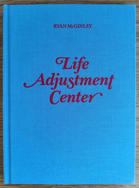 The photobook cover of Life Adjustment Center by Ryan McGinley. In hardcover blue.