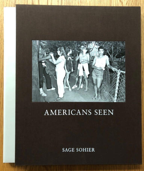 The photography book cover of Sage Sohier. Hardback in black with B&W image of people standing by a fence.