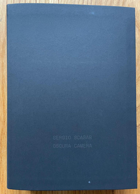The photography book cover of Oscura Camera by Sergio Scabar. Hardback in navy blue.
