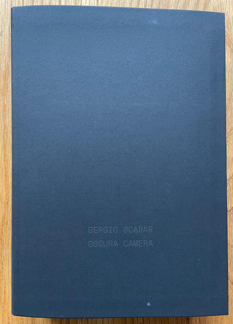 The photography book cover of Oscura Camera by Sergio Scabar. Hardback in navy blue.