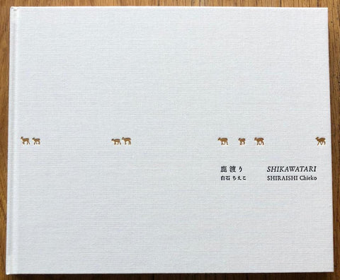 The photography book cover of Shikawatari by Chieko Shiraishi. Hardback in white with tiny deer across the middle.