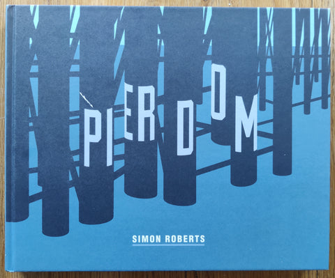 The photobook cover of Pierdom by Simon Roberts . In hardcover blue. Signed.