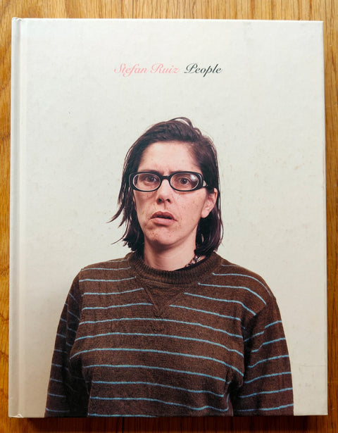 The photobook cover of People by Stefan Ruiz. Hardback cover image of woman in a striped brown and blue top. Signed and dedicated.