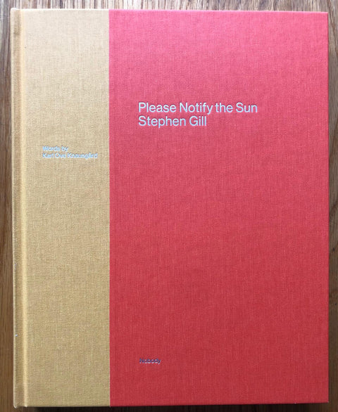 The photography book cover of Please Notify the Sun by Stephen Gill. Red hardback cover with yellow side strip. Signed.
