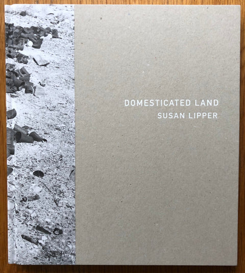 The photography book cover of Domesticated Land by Susan Lipper. Hardback with grey cover.