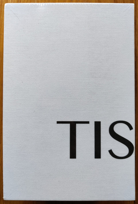 The photography book cover of TIS03: Box Set by Sasha Arutyunova, Tim Carpenter, J Carrier, Nelson Chan, Rose Marie Cromwell, Tenzing Dakpa, Adler Guerrier, Will Matsuda, Yael Malka, Andrea Modica, Aaron Turner, Carl Wooley. In hardcover white.