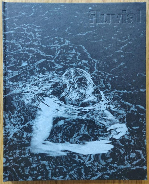 The photography book cover of Fluvial by Tito Mouraz. Hardback with image of someone with their head underwater.
