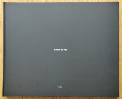 The photography book cover of Between the Two by Todd Hido. Hardback in black with small centred white title.