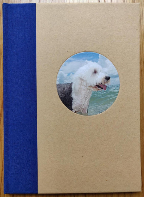 The photography book cover of Floridadogs by Tony Mendoza. Hardback with image of a wet dog in a circle in the middle. Blue binding.