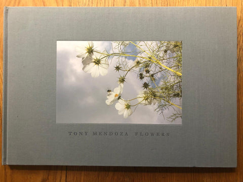 The photography book cover of Flowers by Tony Mendoza. Hardback in grey with flowers in the photograph. Signed.