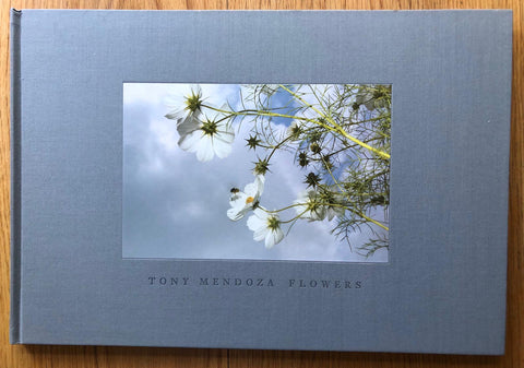 The photography book cover of Flowers by Tony Mendoza. Hardback in light grey/blue with photograph of white flowers.