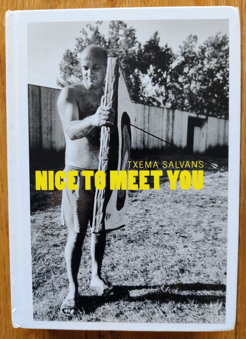 The photography book cover of Nice to Meet You by Txema Salvans. Hardback black and white cover with yellow text.