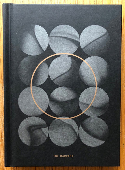 The photography book cover of The Harvest by Valentina Abenavoli. Hardback in black with grey circles.