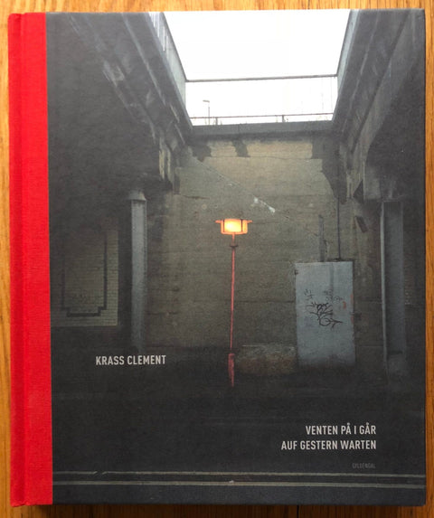 The photography book cover of Venten Pa I Gar by Krass Clement. Hardback with red spine.