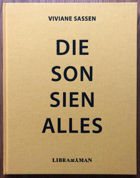 The photobook cover of Die Son Sien Alles by Vivianew Sassen. In hardcover yellow. Numbered