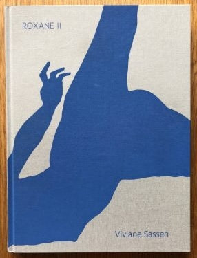 The photography book cover of Roxane II by Viviane Sassen. Hardback beige with blue person on cover.