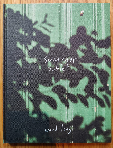 The photography book cover of Summer Sublet by Ward Long. Hardback with photograph of a green door covered in leafy shadows. Signed.