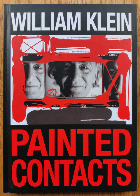 The photography book cover of Painted Contacts by William Klein. Hardback in black with red title.