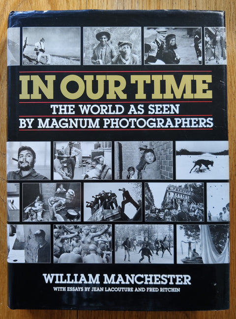 The photobook cover of In Our Time: The World As Seen By Magnum Photographers by William Manchester. In dust jacketed hardcover black.